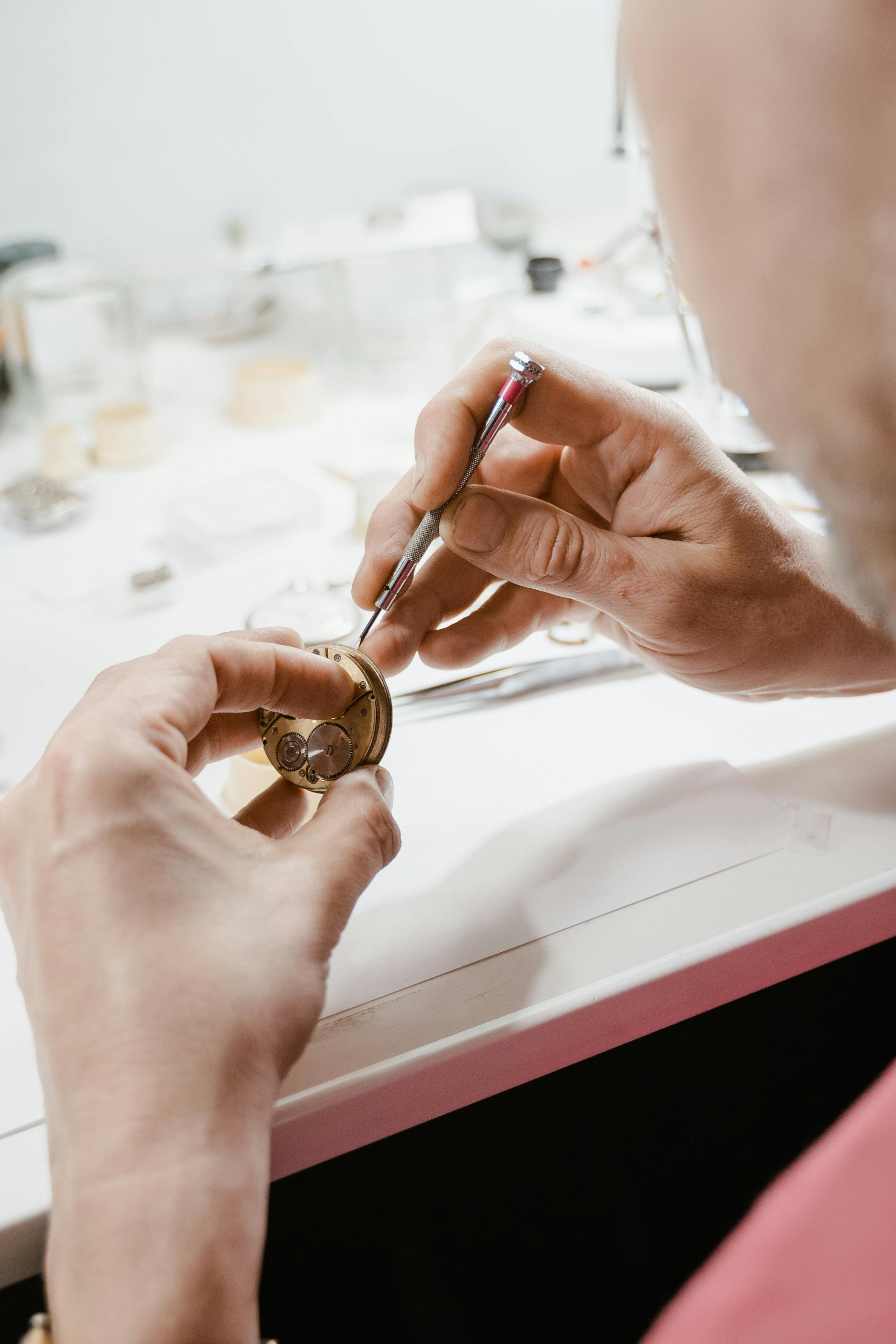 Watchmaker using a precision screwdriver to work on a watch movement during battery replacement